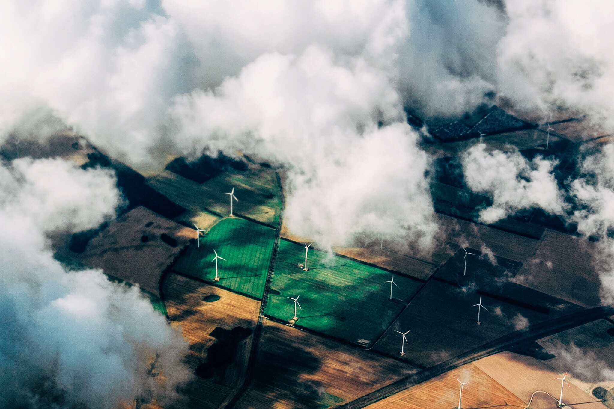 Aerial view of farmland with wind turbines