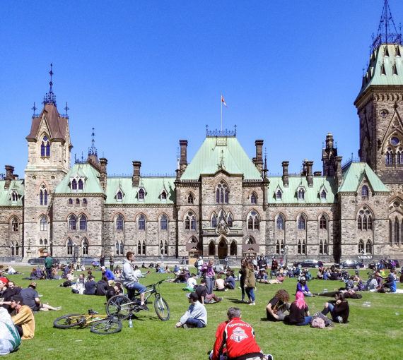 Crowds picnic on Parliament Hill in Ottawa.