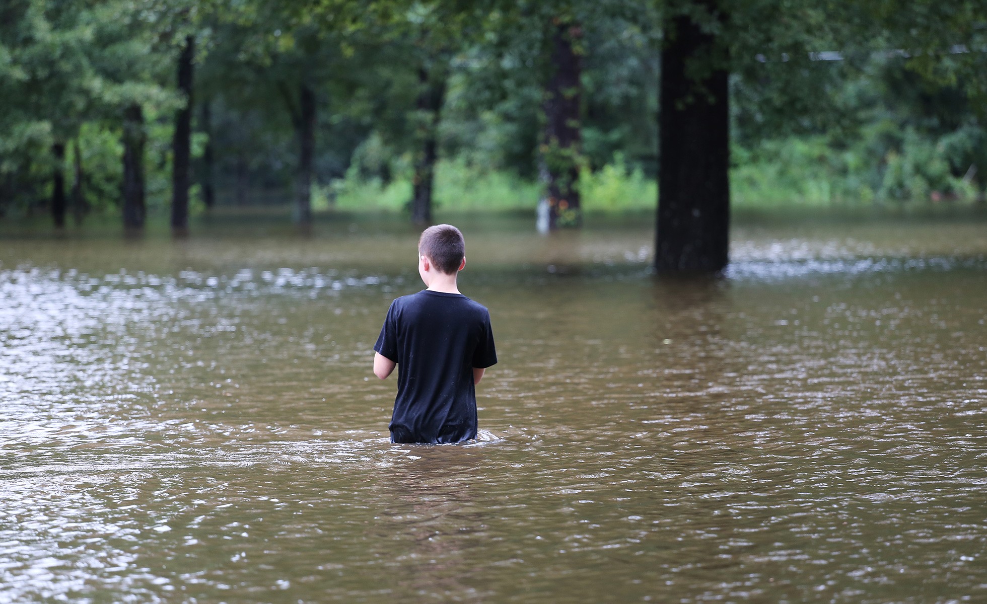 A boy wades through flood waters following Hurricane Harvey.