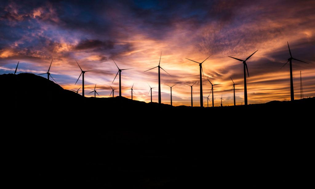 A picture of a wind farm at sunset