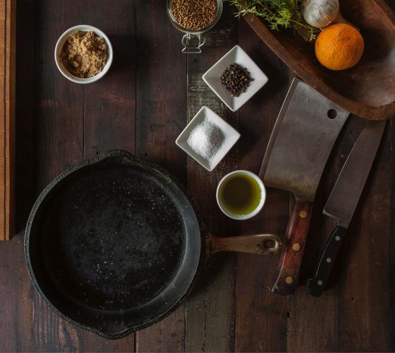 A cast iron pan and other ingredients and cooking equipment.