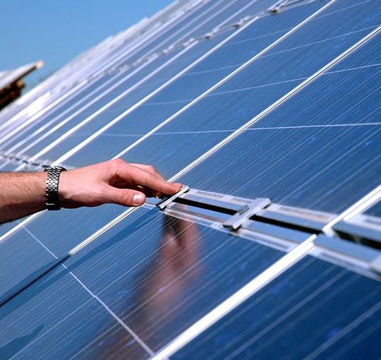 hand-touching-solar-panel_nav A hand touches a solar panel.