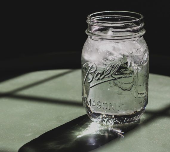A mason jar with purified ice water.