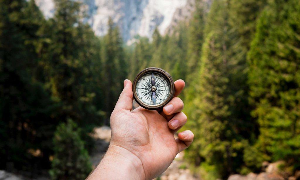 A hand holding a compass