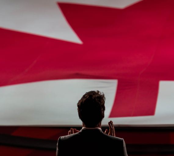 Justin Trudeau in front of a Canada flag