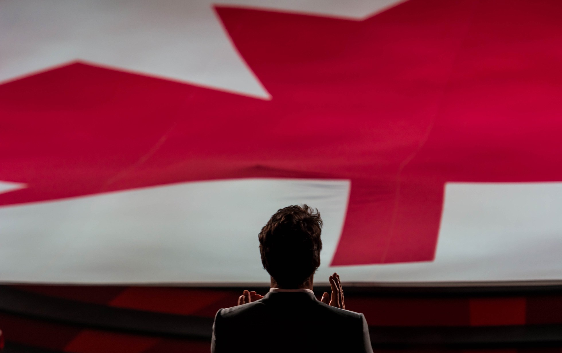 Justin Trudeau in front of a Canada flag