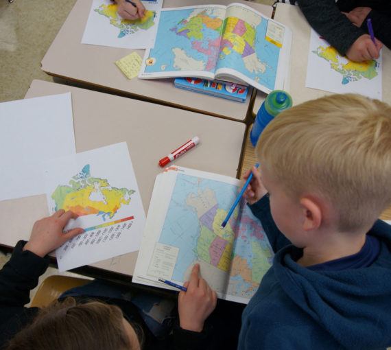 Students study maps of Canada