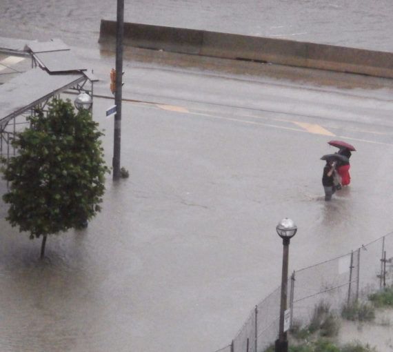 Pedestrians cross a flooded street in Toronto