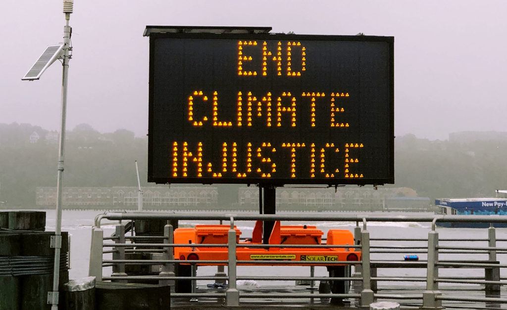 Road sign saying "End climate injustice"
