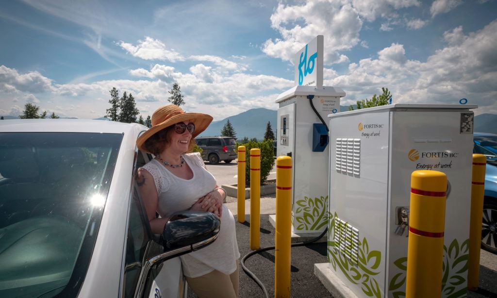 Woman charging an electric vehicle