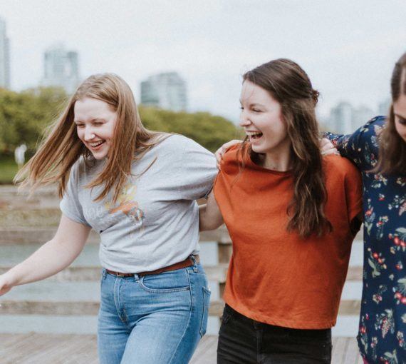 Young women laughing arm-in-arm