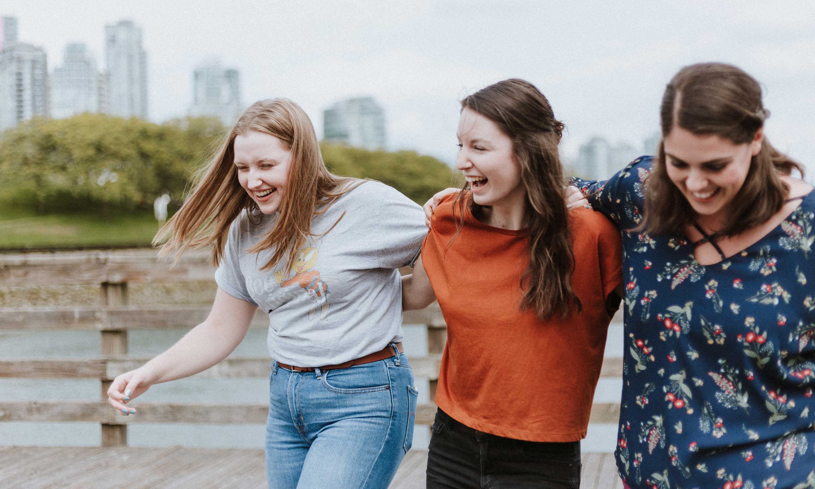 Young women laughing arm-in-arm