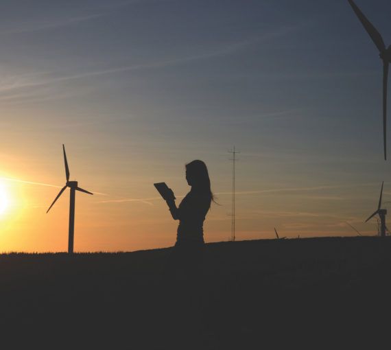 Woman at sunset with wind turbines