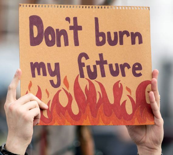 Youth holding climate strike protest sign saying 