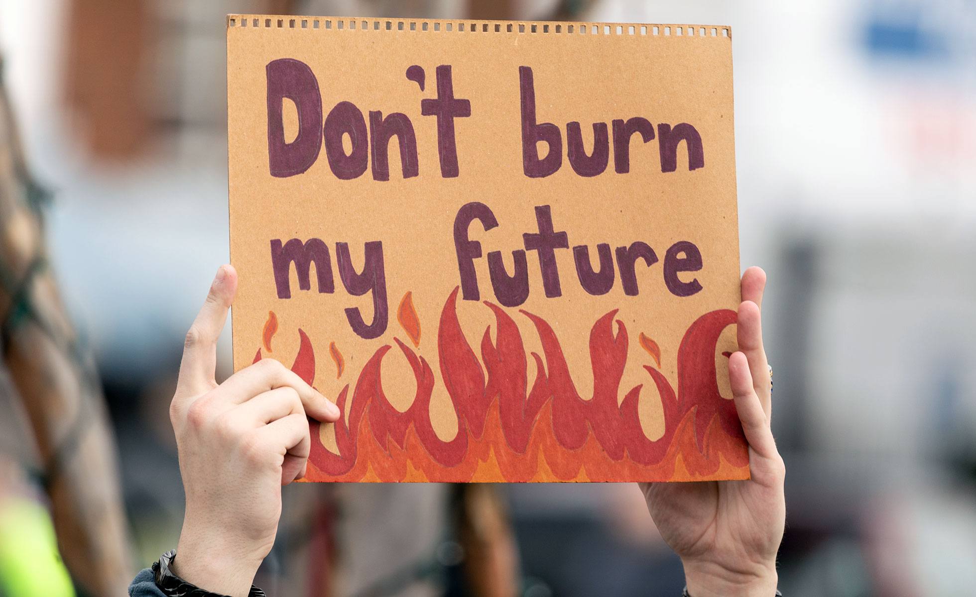 Youth holding climate strike protest sign saying "Don't burn my future"