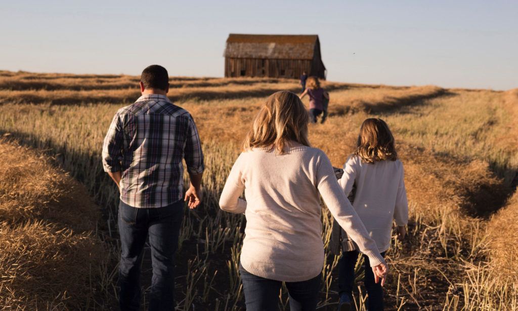 Family walking toward barn in the Prairies