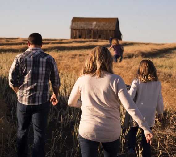 Family walking toward barn in the Prairies