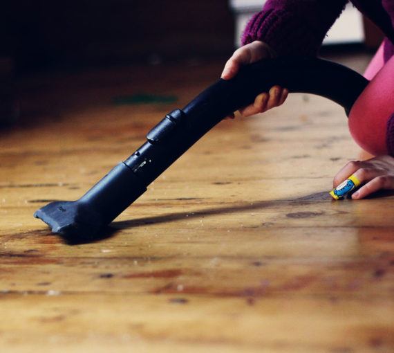 Child vacuuming dust off the floor