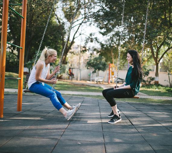 Two young friends on swings deciding to become voting buddies