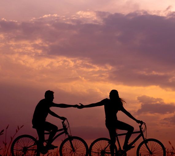 Cyclists celebrate their friendship at sunset