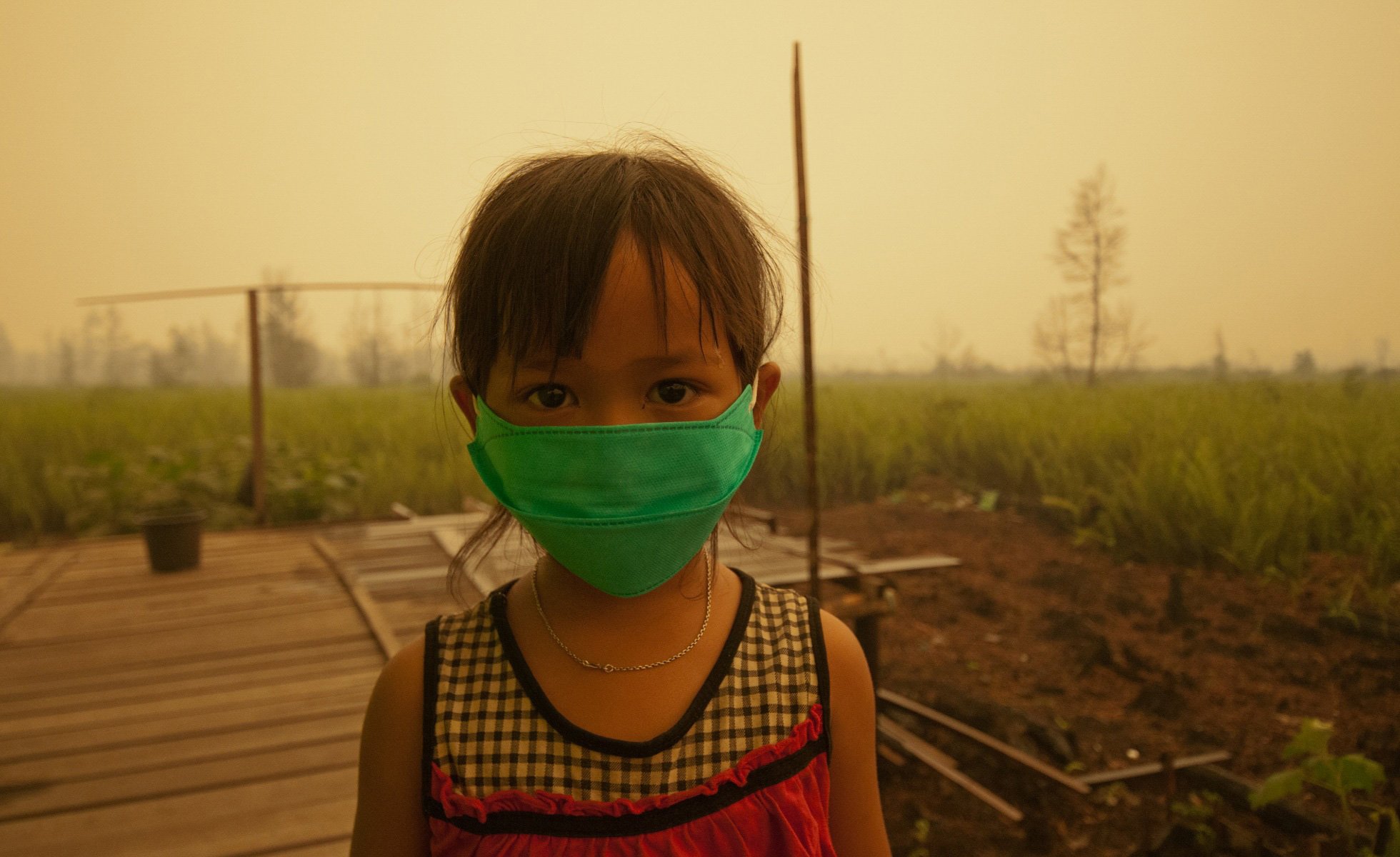 Child wearing masks due to the toxic smoke from peat land fires