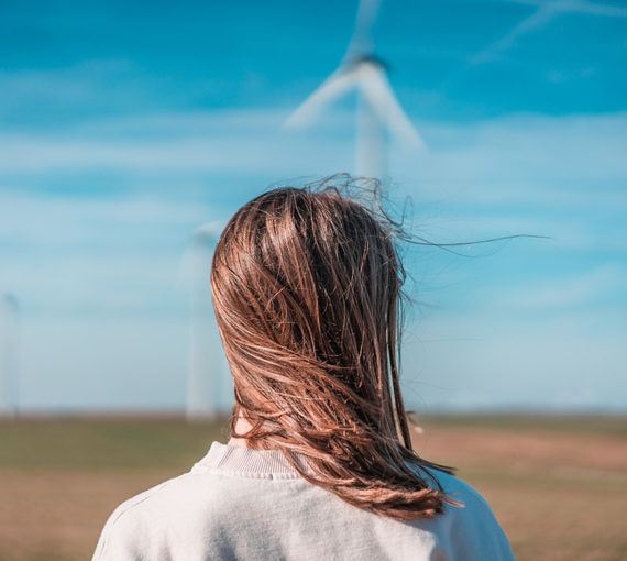 Young woman and renewable energy wind turbine