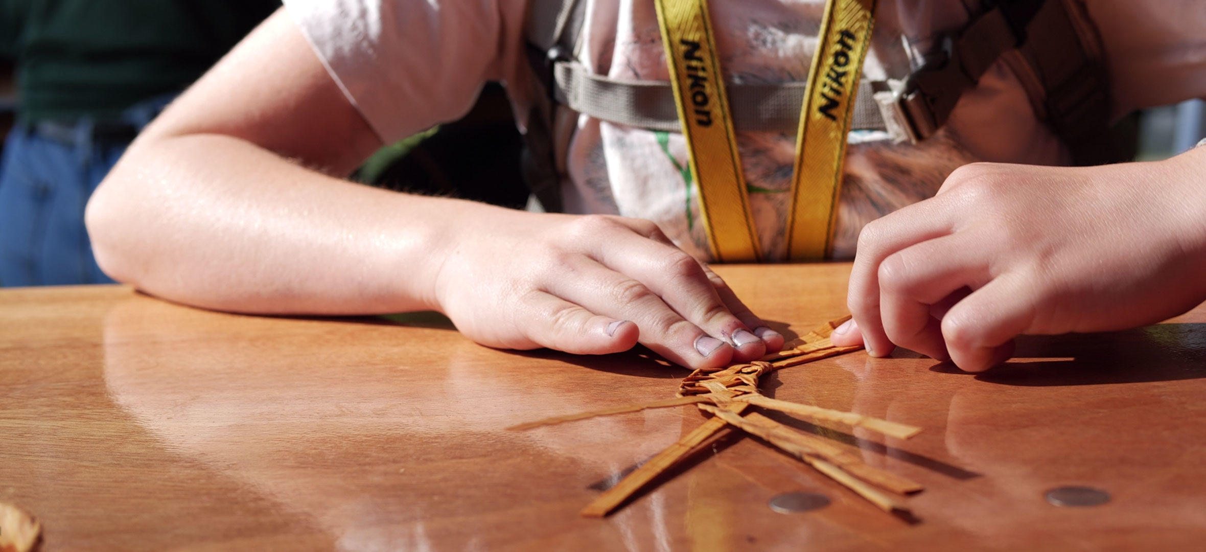 Child weaving cedar, a Squamish Nation tradition
