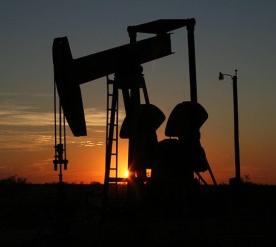 oil and gas well backlit by sunset