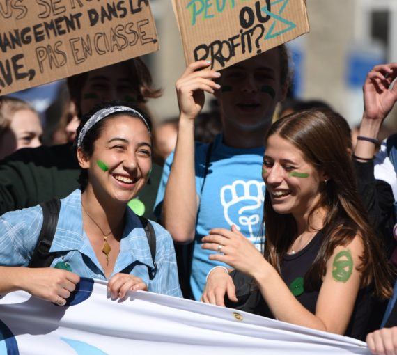 Youth behind smiling behind banner at 2019 youth climate march in Montreal