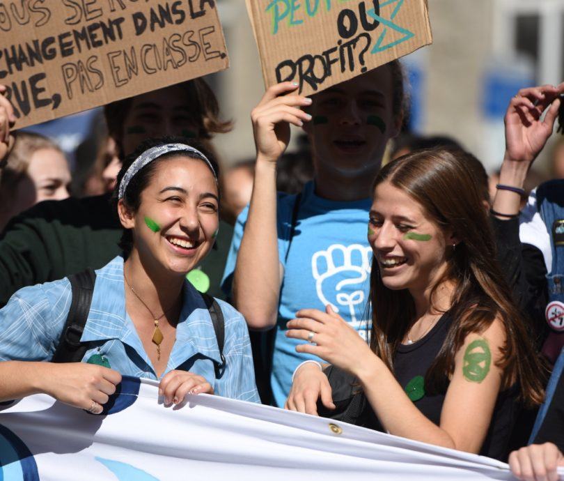 youth-climate-march-montreal-2019 Youth behind smiling behind banner at 2019 youth climate march in Montreal
