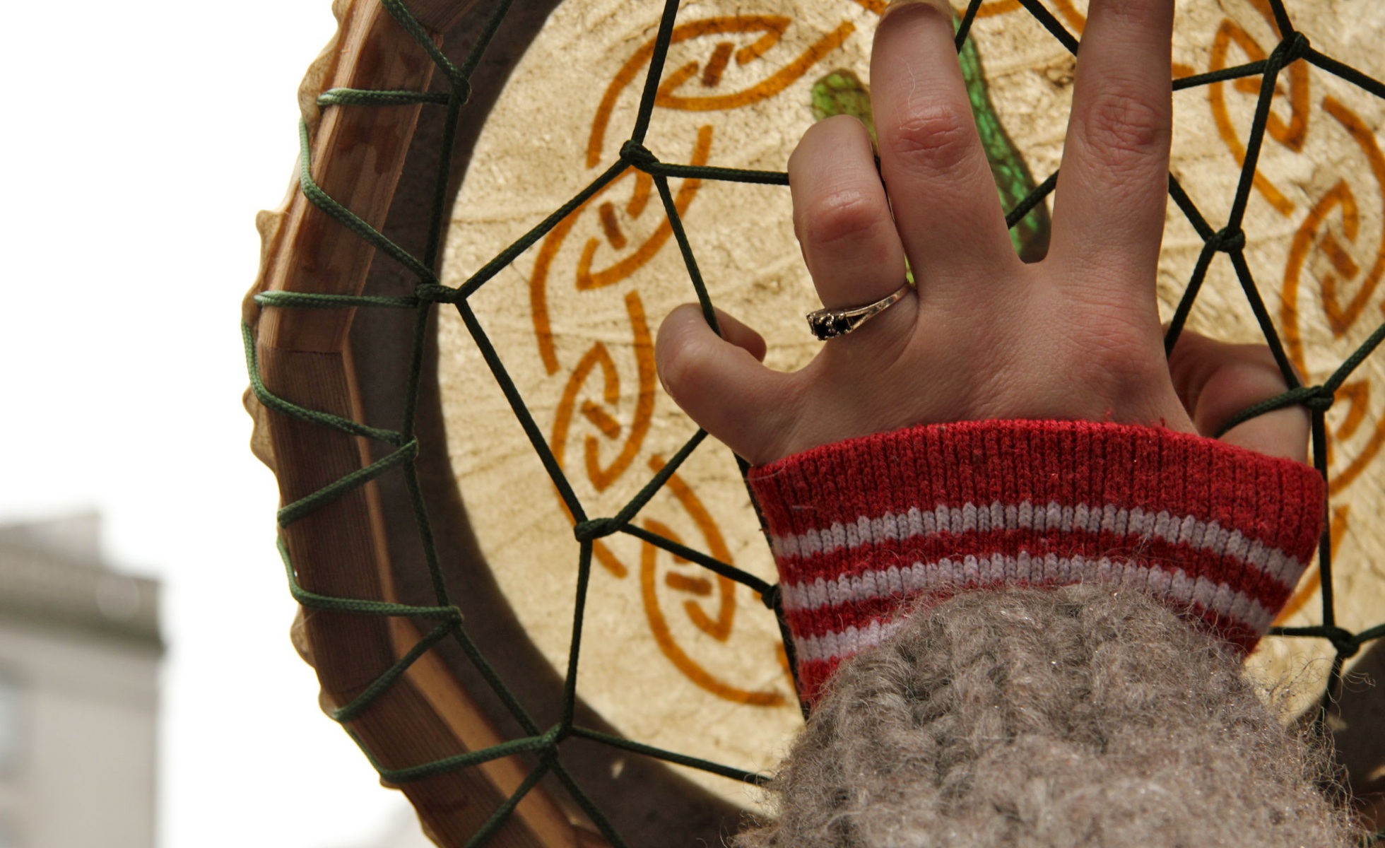 Close up of hand holding hide hand drum