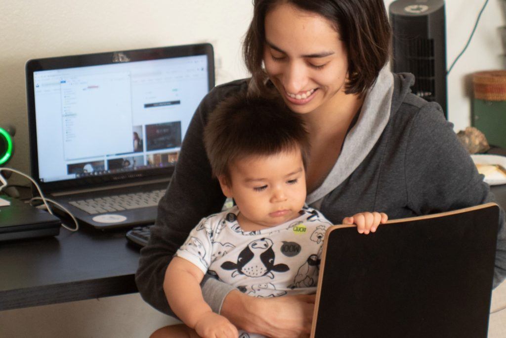Parent holding baby at home work station