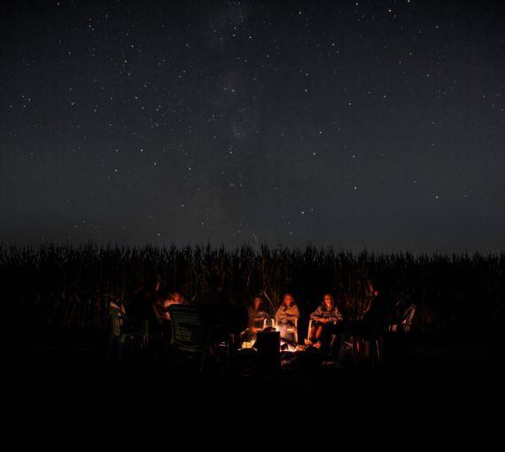Group of people camping under star-lit sky