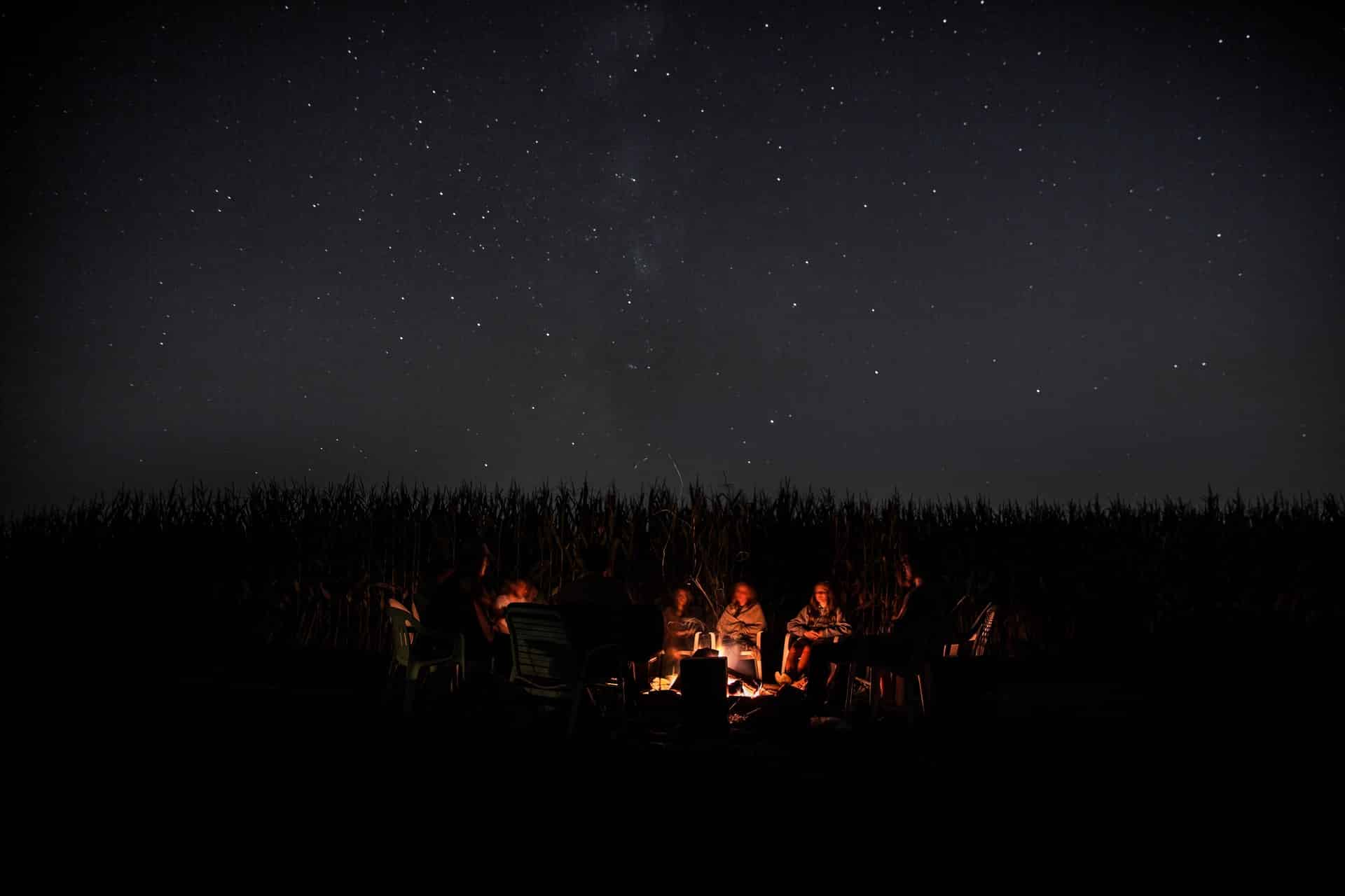 Group of people camping under star-lit sky