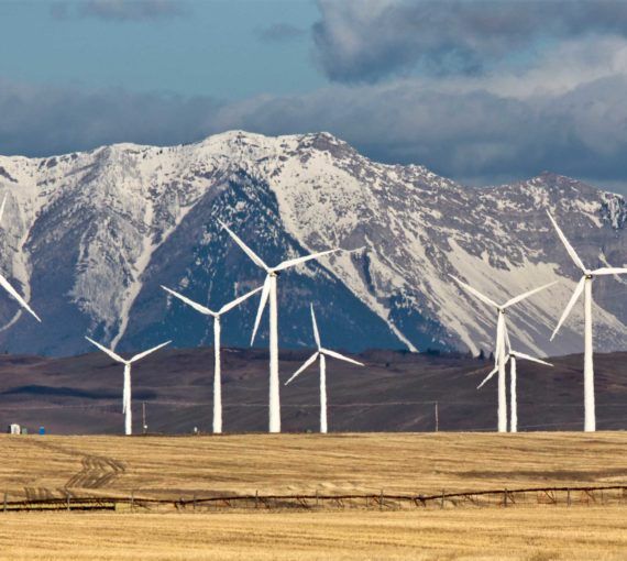 Wind turbines in a field in front of mountain range
