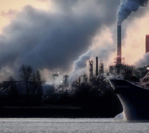 Smoke stacks and tanker photo representing climate pollution