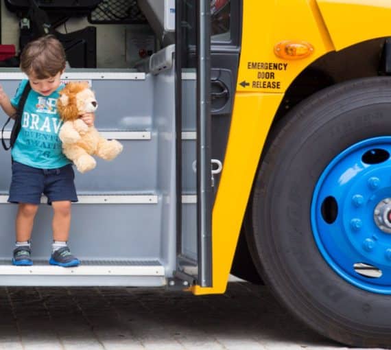A child stepping off an electric school bus