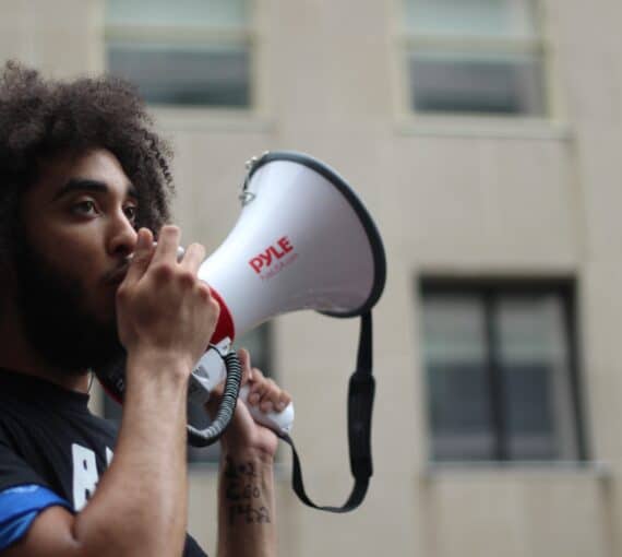 Young man holds megaphone.