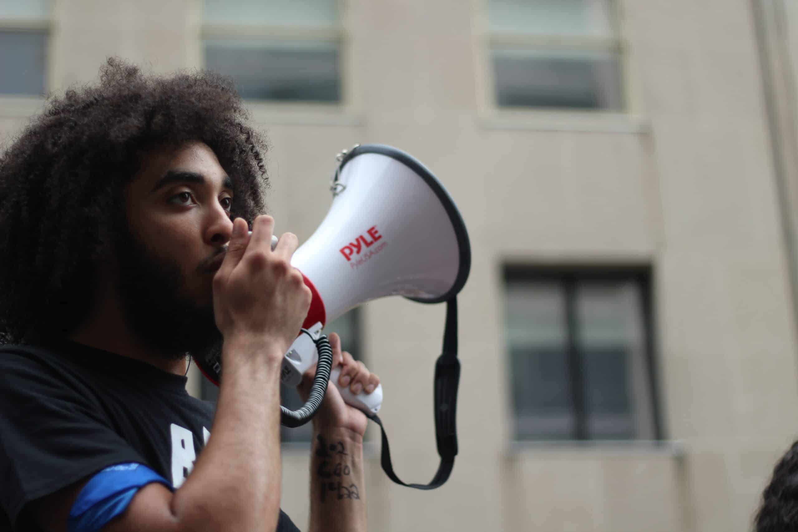 Young man holds megaphone.
