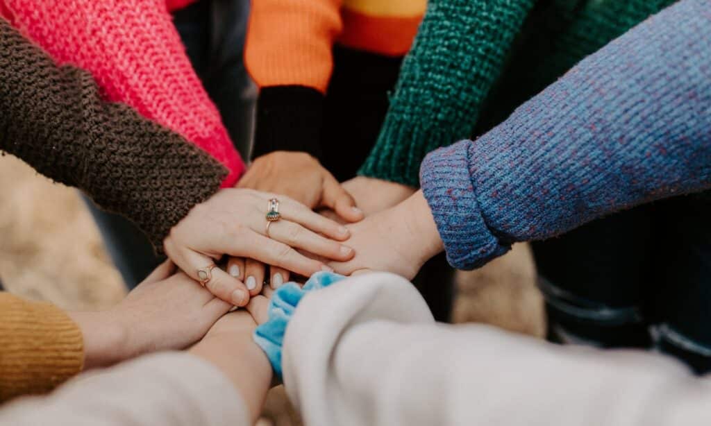 Photo of group of people putting their hands together