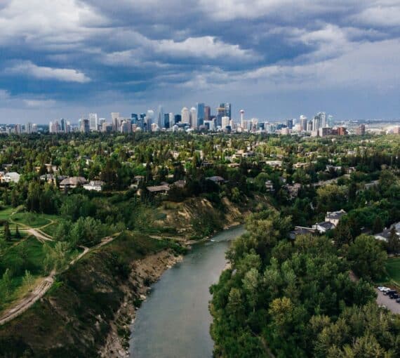 Aerial view of Calgary city buildings and trees under cloudy sky during daytime