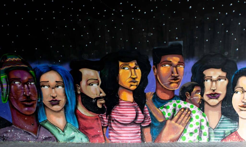 A mural of several people and a child in bright colours under a starry night sky