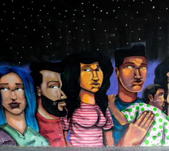 A mural of several people and a child in bright colours under a starry night sky
