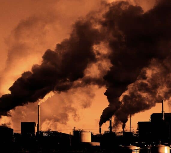 An orange sky with smoke stacks