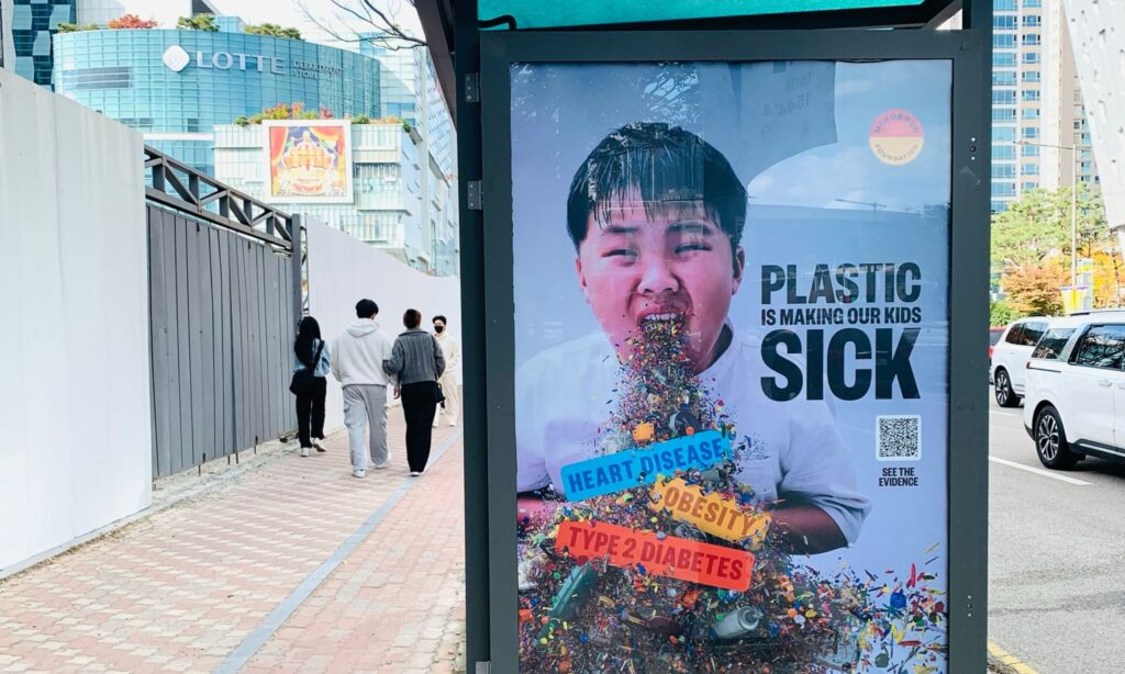 Bus stop sign reading 'plastic is making our kids sick'