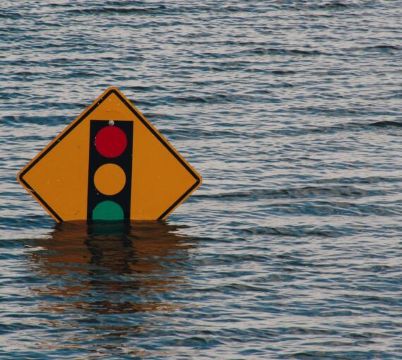 A traffic light sign almost under water due to flooding