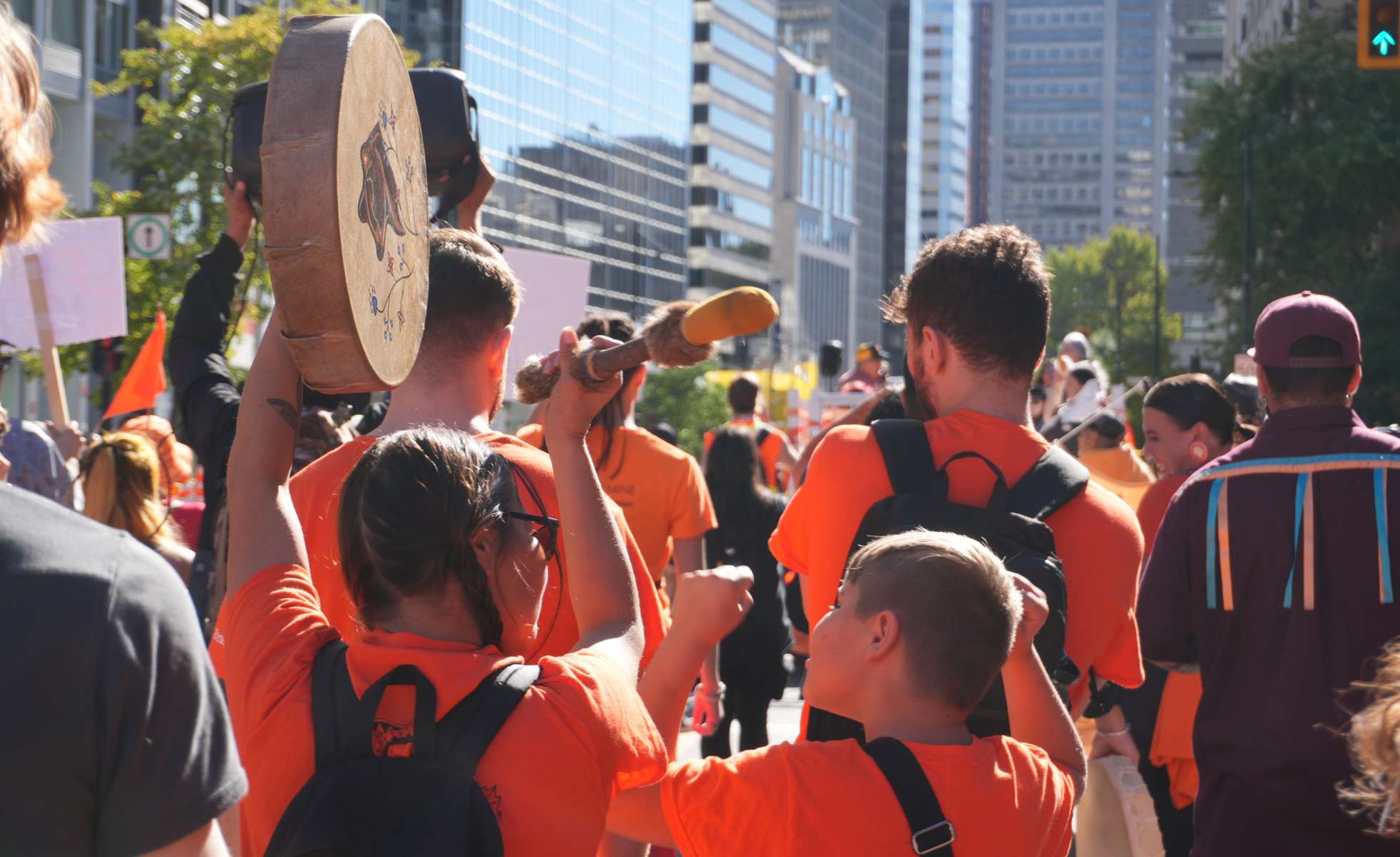People at an 'Every Child Matters' march banging a drum, 2025