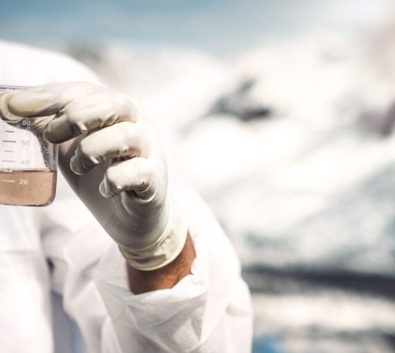 an image of a lab technician holding a beaker of fluid