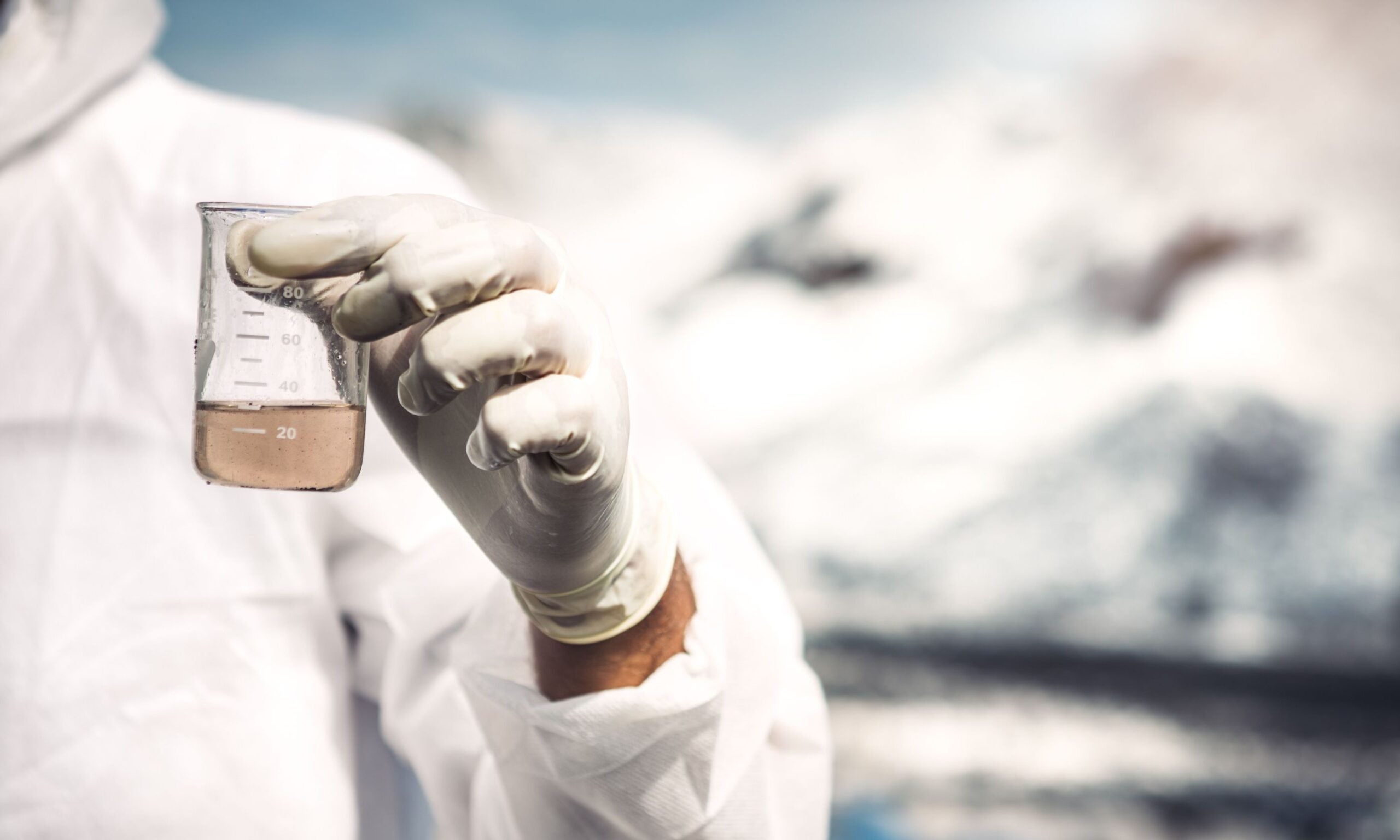 an image of a lab technician holding a beaker of fluid